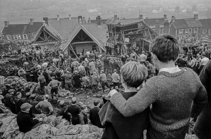 Two surviving children watch the miners digging to find children still buried in the slag that swept over their school: David Hurn's iconic photograph